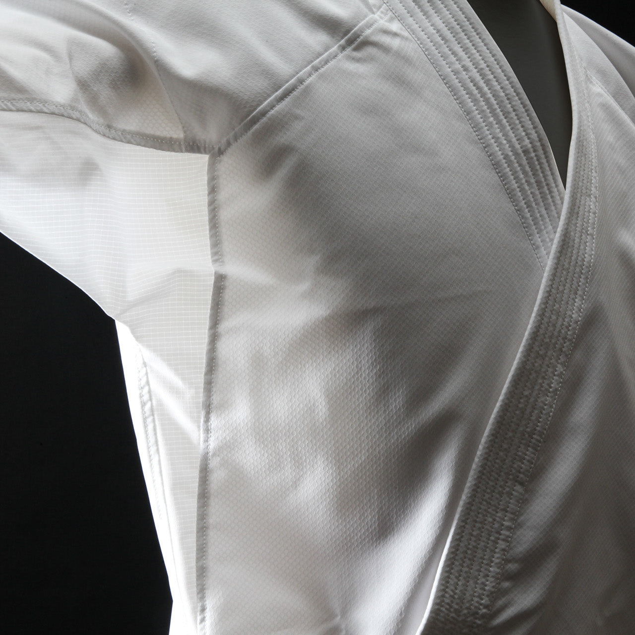 Close-up of a white martial arts uniform on a black background