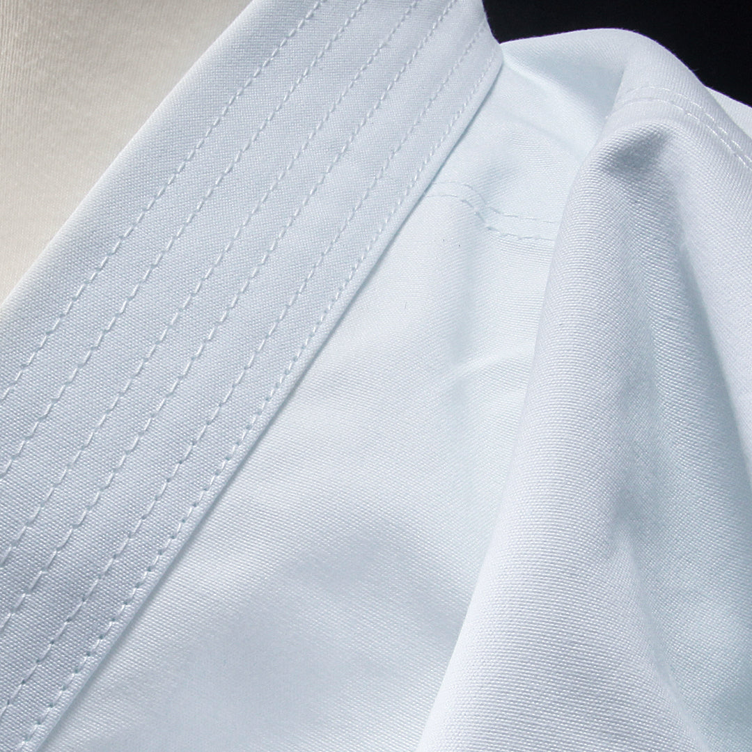 Close-up of a white martial arts gi with visible stitching details.