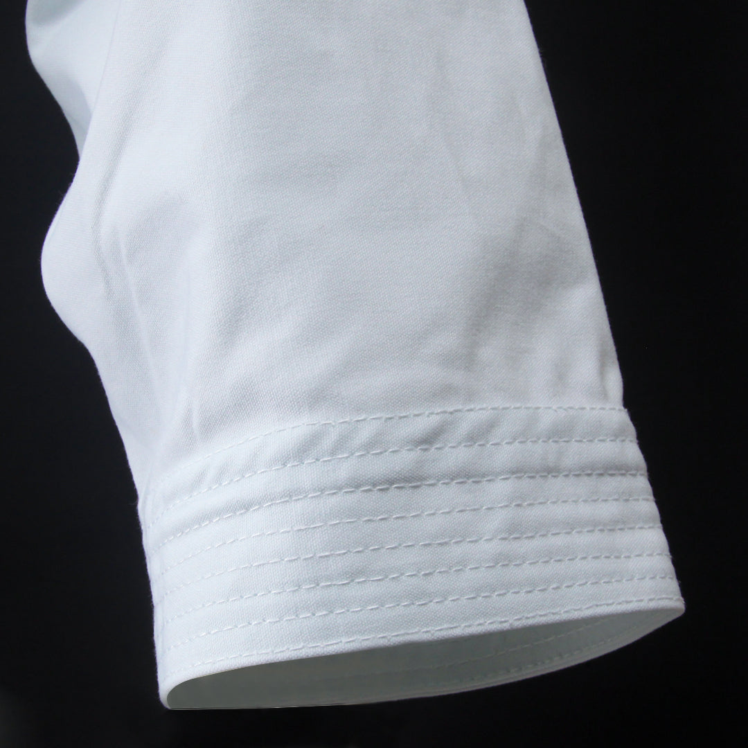 Close-up of a white sleeve with stitching detail on a black background