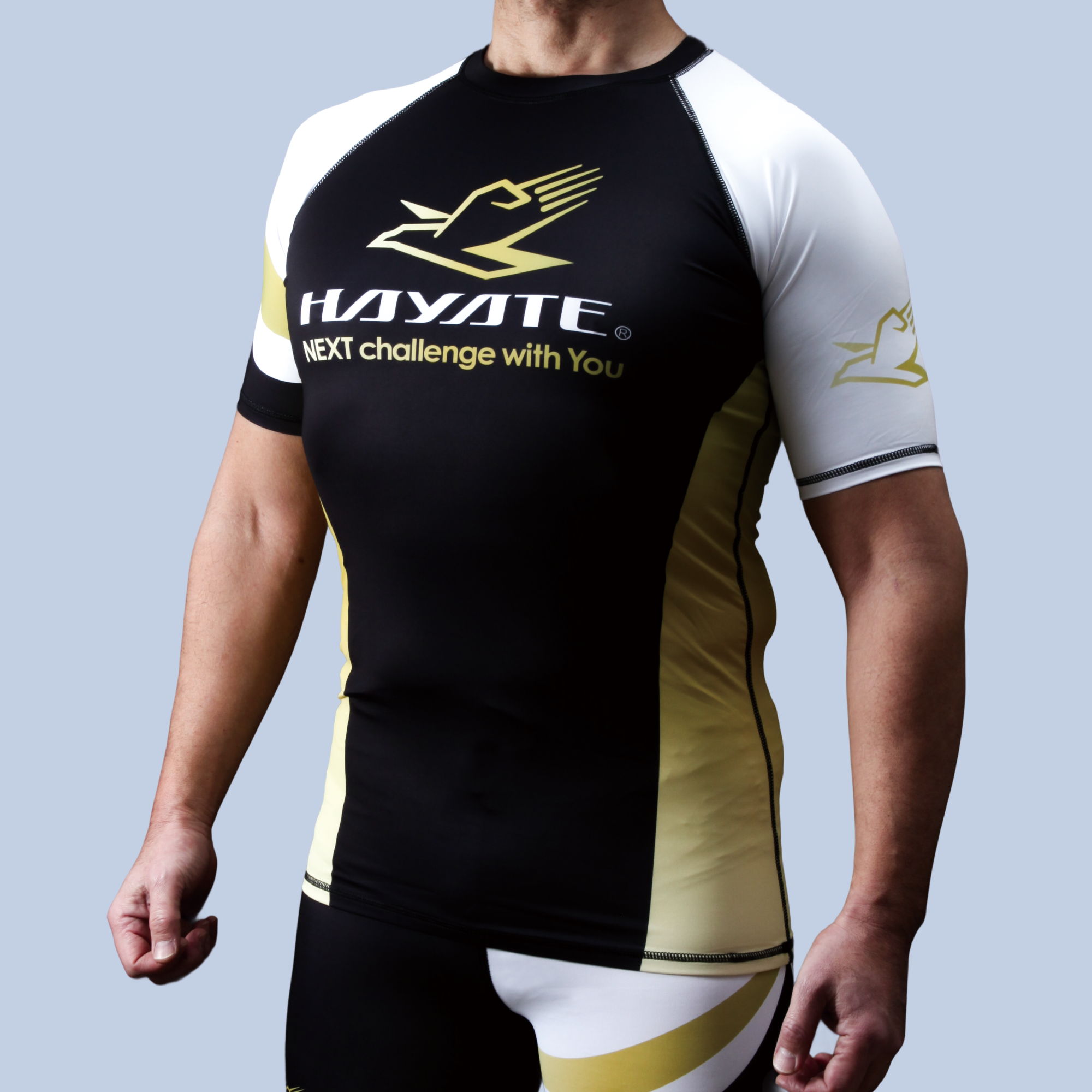 Person wearing a black, white, and yellow sports outfit with 'Hayate' branding on a light gray background.